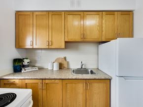 Toronto apartment for rent - A kitchen with wooden cabinets and a white refrigerator.