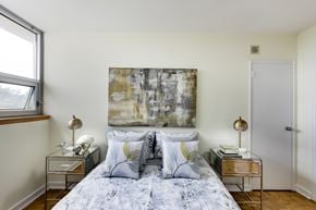 Toronto apartment for rent - A bedroom with a large bed and a painting on the wall.