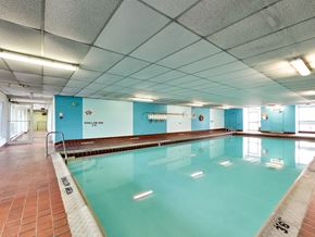Mississauga apartment for rent - a large swimming pool in a building with blue walls