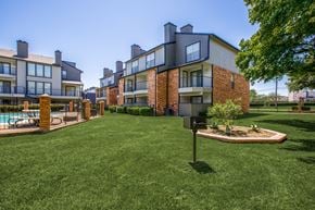 Dallas apartment for rent - A grassy area in front of a building with a mailbox.