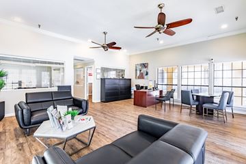 Dallas apartment for rent - A living room with black leather furniture and a ceiling fan.