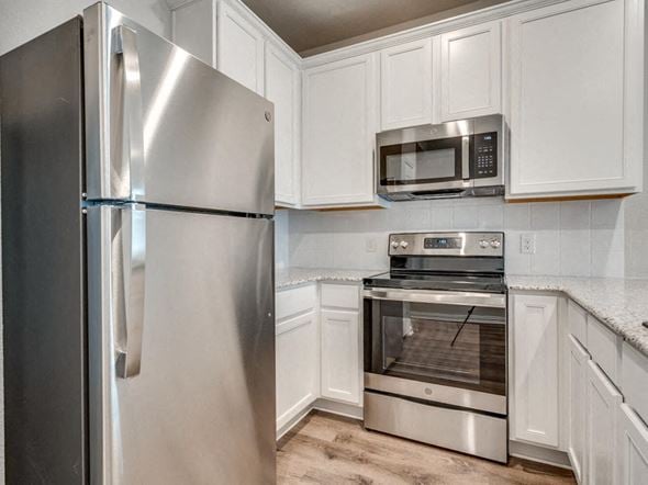 Fort Worth apartment for rent - a kitchen with stainless steel appliances and white cabinets