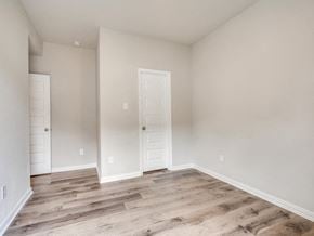 Fort Worth apartment for rent - the living room of a home with a white door and wood flooring