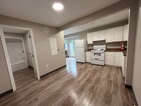 Kingston apartment for rent - A kitchen with white cabinets and a wooden floor.