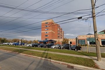 Kingston apartment for rent - a parking lot with cars in front of a brick building