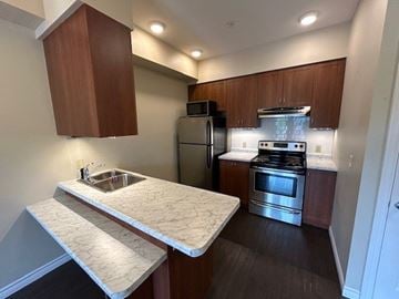 Kingston apartment for rent - A kitchen with a stove top oven and a sink.