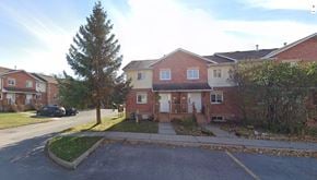Kingston townhouse for rent - the front yard of a brick house with a sidewalk and a tree