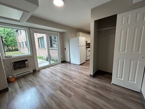 Kingston apartment for rent - A kitchen with a white fridge and a white door.