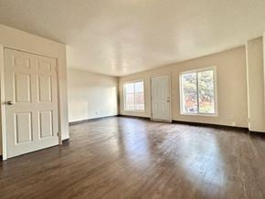 Kingston townhouse for rent - an empty living room with wood floors and a white door