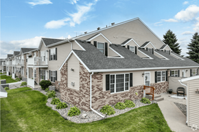 Grand Forks apartment for rent - a row of townhouses with grass and a bench in front of them