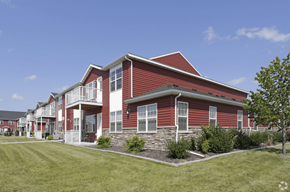 Grand Forks apartment for rent - A red house with white trim and a stone foundation.