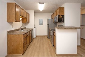 Grand Forks apartment for rent - A kitchen with wooden cabinets and a granite counter top.