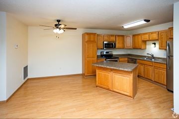 Grand Forks apartment for rent - A kitchen with wooden cabinets and a granite countertop.