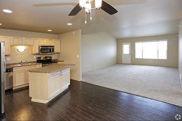 Grand Forks apartment for rent - A spacious kitchen with wooden floors and a ceiling fan.