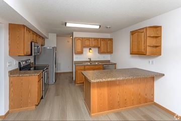 Grand Forks apartment for rent - A kitchen with wooden cabinets and a granite counter top.