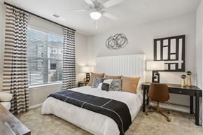 Raleigh apartment for rent - a large bedroom with a ceiling fan and large window