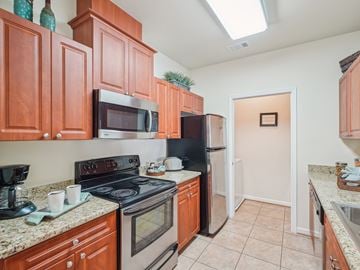 Raleigh apartment for rent - A kitchen with brown cabinets and black appliances.
