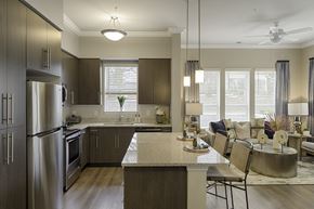 Richmond apartment for rent - Kitchen with dark cabinets, granite countertops, vinyl wood plank floors; island; open to living room