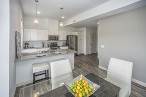 Buffalo apartment for rent - A modern kitchen with a glass table and white chairs.