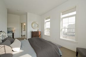 Buffalo apartment for rent - A bedroom with a large bed and a dresser with a mirror.