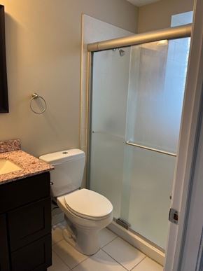 Buffalo apartment for rent - A white toilet sits in a bathroom next to a walk-in shower.