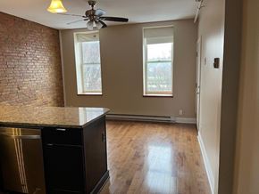 Buffalo apartment for rent - A kitchen with a black fridge and a ceiling fan.