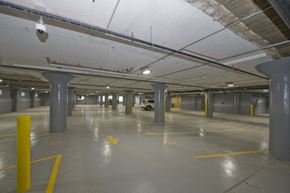 Buffalo apartment for rent - a large parking garage with pillars and a yellow arrow in the floor