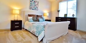 Boynton Beach apartment for rent - A bedroom with a large bed, two lamps, and a dresser.