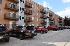Woodmere apartment for rent - a parking lot full of cars in front of an apartment building