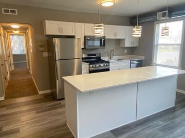 University Heights apartment for rent - a kitchen with white cabinets and stainless steel appliances