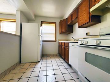 Cleveland Heights apartment for rent - a kitchen with white appliances and wooden cabinets