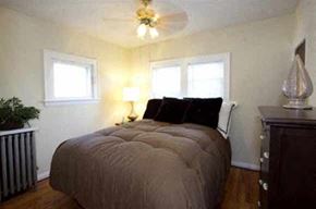Lakewood apartment for rent - a bedroom with a large bed and a ceiling fan