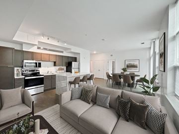 Silver Spring apartment for rent - A modern living room with a grey sofa and a kitchen area in the background.