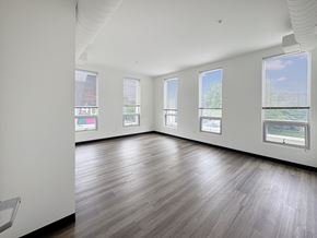 Washington apartment for rent - A large empty room with wooden floors and white walls.