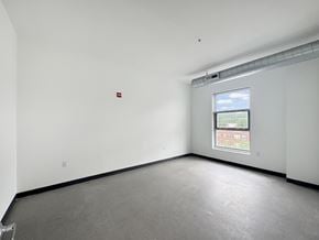 Mount Rainier apartment for rent - A large empty room with a window and a fire extinguisher on the wall.