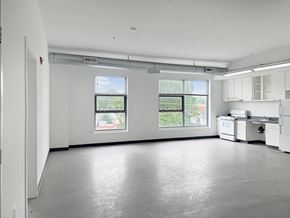 Mount Rainier apartment for rent - A large empty room with a kitchenette and two windows.