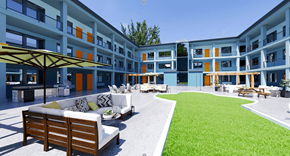 Oklahoma City apartment for rent - a grassy courtyard with a couch and chairs in front of a building