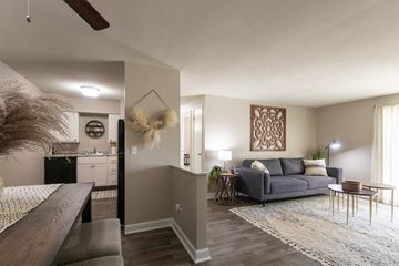 Cincinnati apartment for rent - an open living room and kitchen with a couch and a table