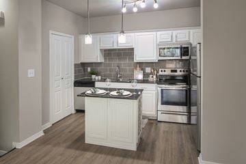 Dallas townhouse for rent - A kitchen with a white island and stainless steel appliances.