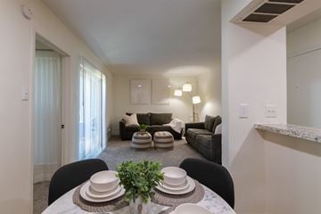 Dallas apartment for rent - A dining table with plates and a plant on it in a living room.