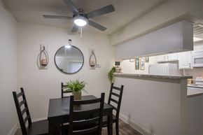 Dallas apartment for rent - A dining room with a table and chairs in a 515 square foot 1 bedroom, 1 bath apartment home at Canyon Creek Apartments in Dallas Midtown neighborhood of Dallas, TX.