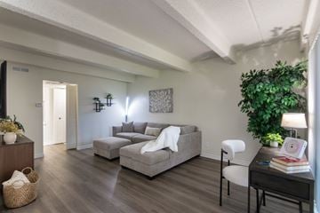 Dallas apartment for rent - A living room with a grey couch and a white chair.