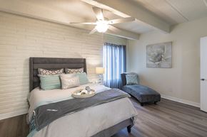 Dallas apartment for rent - Bedroom with ceiling fan, wide window, and wood-look flooring in a one-bedroom apartment home at Harvard Square Apartments