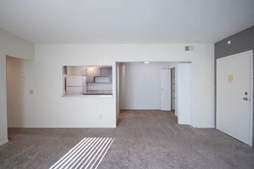 Cincinnati apartment for rent - the living room and kitchen of an apartment with white walls and carpet