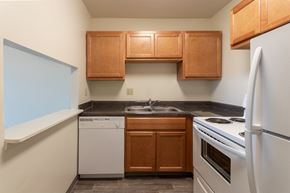 Cincinnati apartment for rent - This is a photo of a kitchen with honey oak cabinets and white appliances in a 560 square foot 1, 1 bath apartment at Park Lane Apartments in Cincinnati, OH.