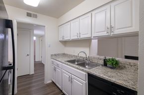 Dallas apartment for rent - A kitchen with black appliances and white cabinets in a 2 bedroom, 2 bath 970 square foot apartment home at Preston Park Apartments in the Far North Dallas neighborhood of Dallas, TX