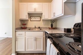 Cincinnati apartment for rent - A kitchen with white cabinets and a black stove top.