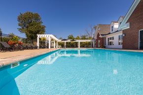 Centerville apartment for rent - A swimming pool in front of a house with a white pergola.