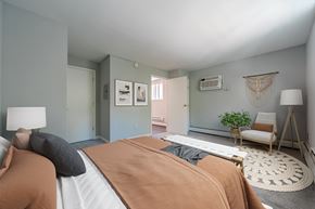 Philadelphia apartment for rent - A bedroom with a bed, a chair, and a plant.