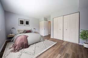 Philadelphia apartment for rent - A bedroom with a bed, a pink blanket, a rug, and a plant.
